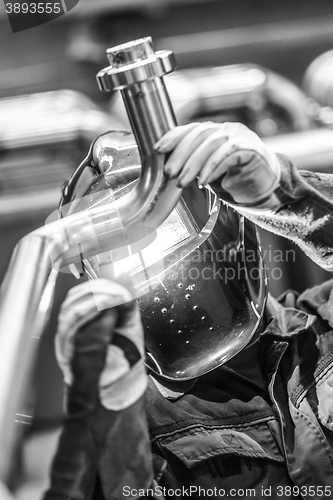 Image of Industrial worker welding in metal factory.