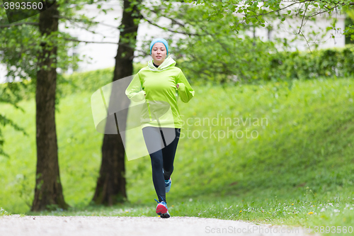 Image of Sporty young female runner in city park.. 