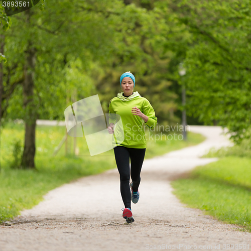 Image of Sporty young female runner in city park.. 