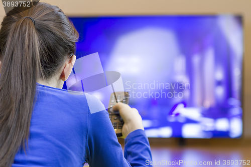 Image of Tennager girl laying down and watching at tv 