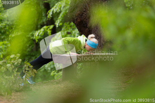 Image of Sporty woman  working out in forest. 