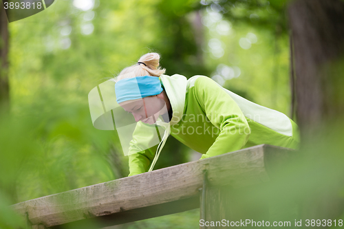 Image of Sporty woman  working out in forest. 