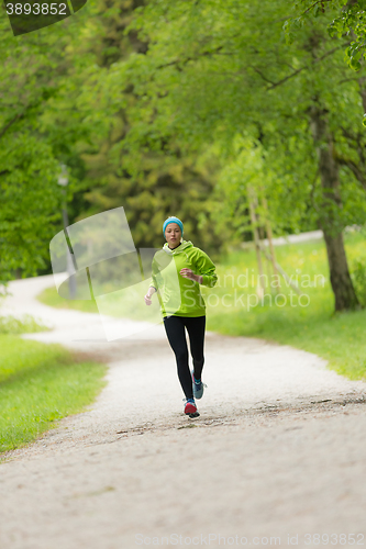 Image of Sporty young female runner in city park.. 