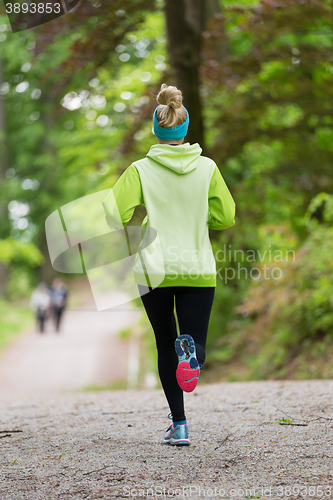 Image of Sporty young female runner in the forest. 