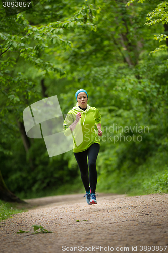 Image of Sporty young female runner in the forest. 