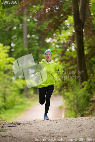 Image of Sporty young female runner in the forest. 