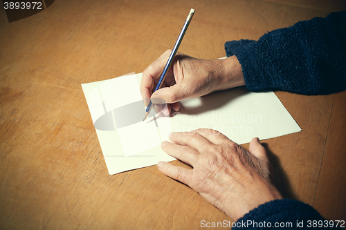 Image of Senior man with blank white paper sheet and pencil