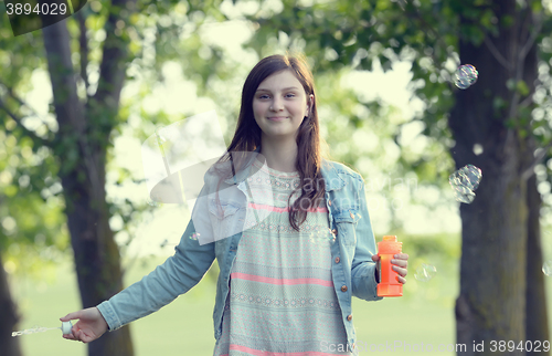 Image of Girl play with soap-bubbles in forest