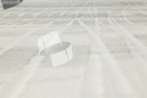 Image of Background representing traces of automobile wheels on white san