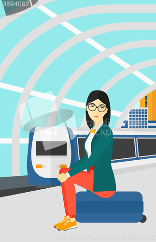 Image of Woman sitting on railway platform.