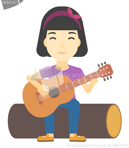 Image of Woman playing guitar.