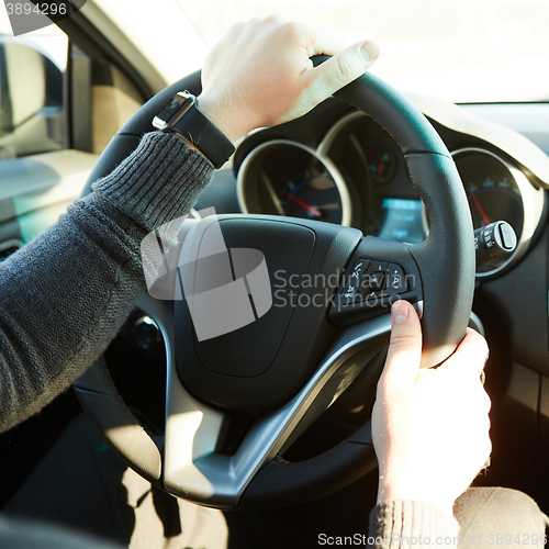 Image of Close-up Of A Man Hands Holding Steering Wheel While Driving Car