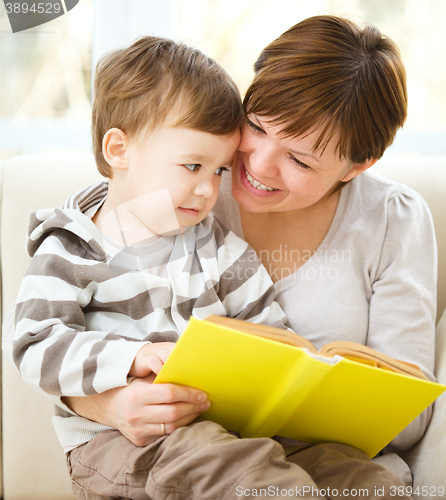 Image of Mother is reading book for her son