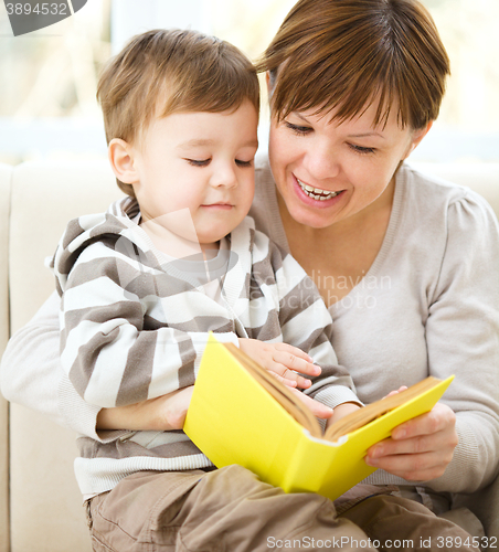 Image of Mother is reading book for her son