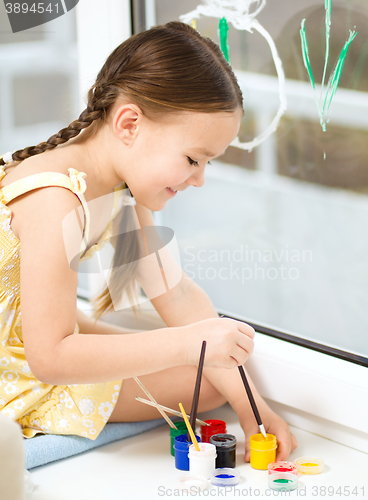 Image of Portrait of a cute girl playing with paints
