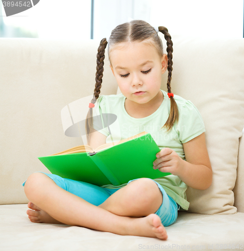 Image of Little girl reads a book