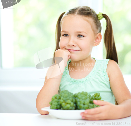 Image of Cute little girl is eating green grapes