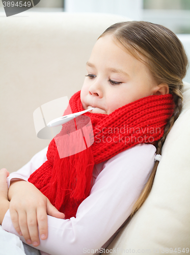 Image of Ill little girl with thermometer in her mouth