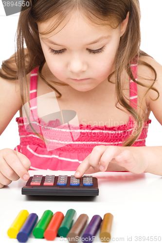 Image of Little girl is playing with calculator