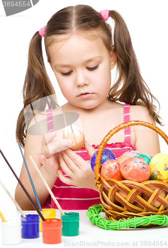Image of Little girl is painting eggs preparing for Easter