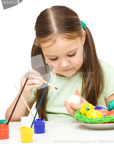 Image of Little girl is painting eggs preparing for Easter