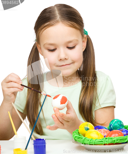 Image of Little girl is painting eggs preparing for Easter