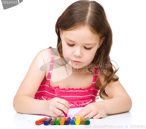 Image of Little girl is drawing using a crayons