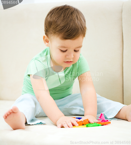 Image of Little boy playing with toys