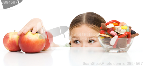 Image of Little girl is reaching apple