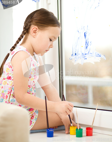 Image of Portrait of a cute girl playing with paints