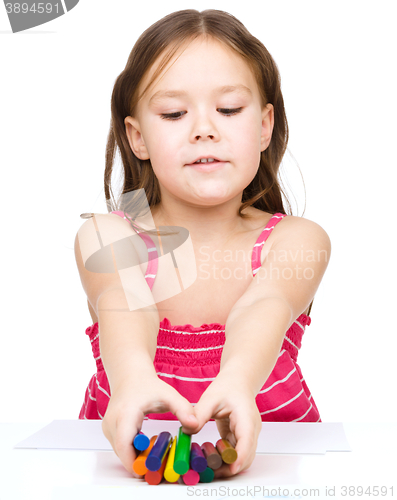 Image of Little girl is drawing using a crayons