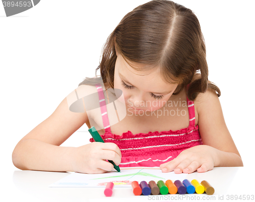 Image of Little girl is drawing using a crayon