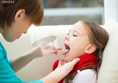 Image of Doctor is examining little girl