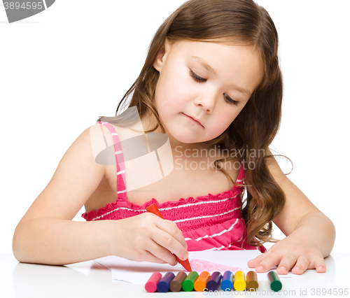 Image of Little girl is drawing using a crayons