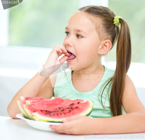 Image of Cute little girl is eating watermelon