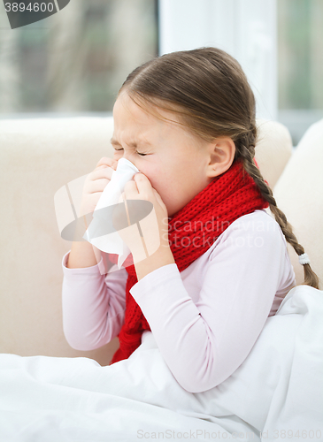 Image of Little girl is blowing her nose