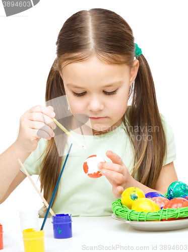 Image of Little girl is painting eggs preparing for Easter