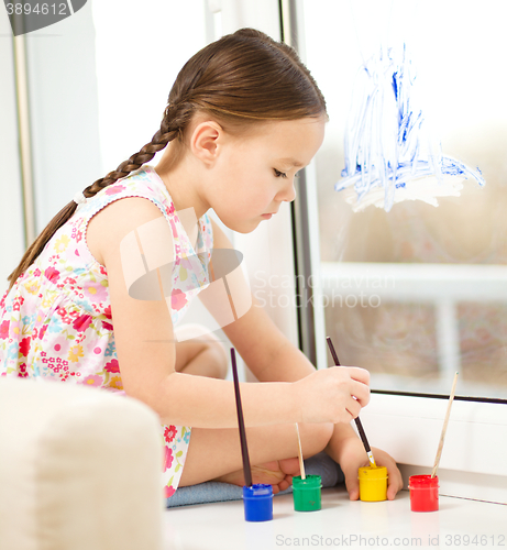 Image of Portrait of a cute girl playing with paints