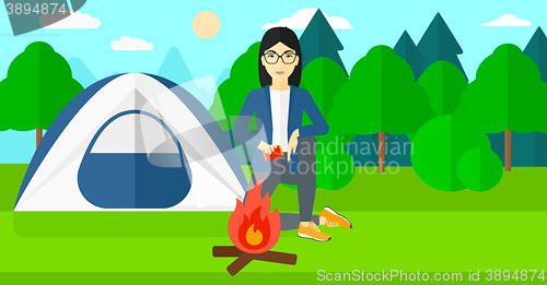 Image of Woman kindling fire.