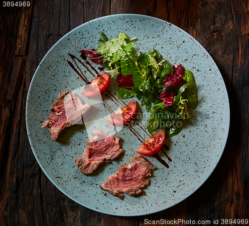 Image of Grilled sliced roast beef and green salad