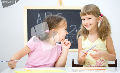 Image of Little girls are writing using a pen