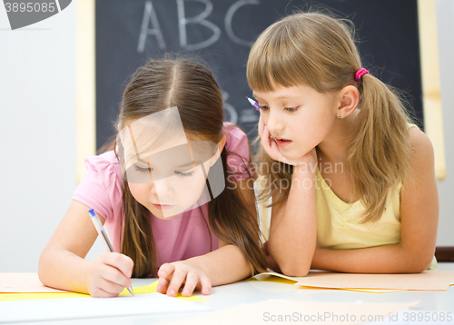 Image of Little girls are writing using a pen