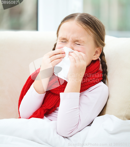 Image of Little girl is blowing her nose