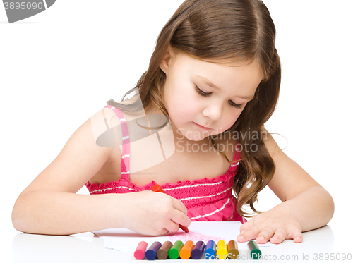 Image of Little girl is drawing using a crayon