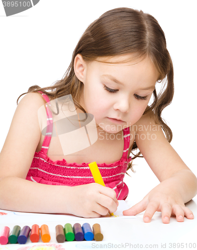 Image of Little girl is drawing using a crayons