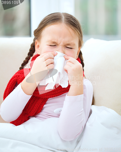 Image of Little girl is blowing her nose