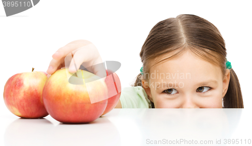 Image of Little girl is reaching apple