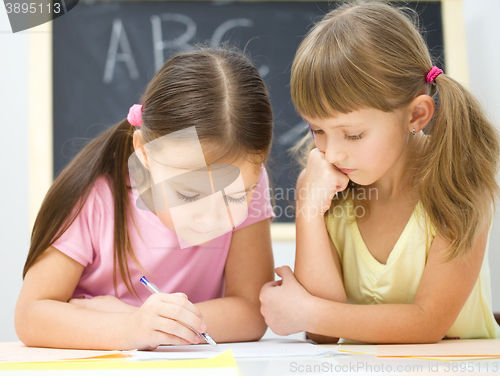 Image of Little girls are writing using a pen