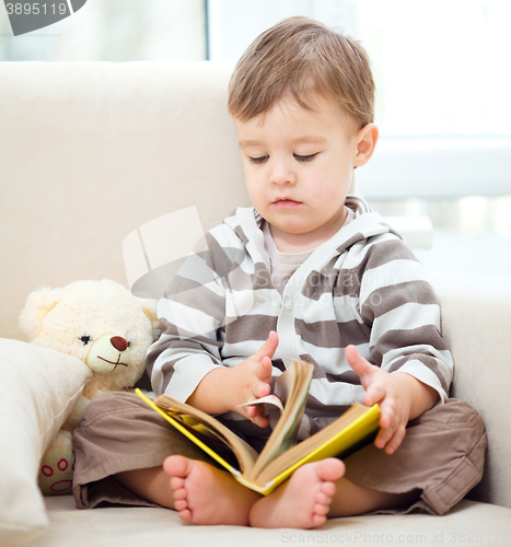 Image of Little boy is reading book