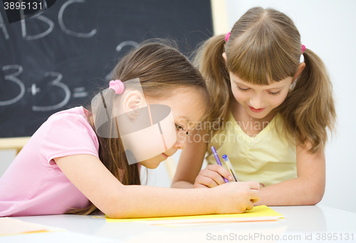 Image of Little girls are writing using a pen